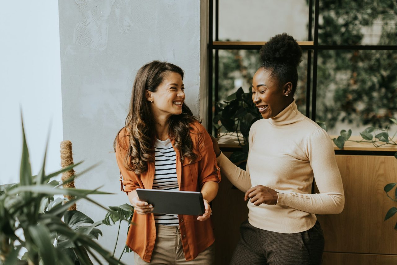 two young business women with digital tablet standing in the modern office Startup Coaching